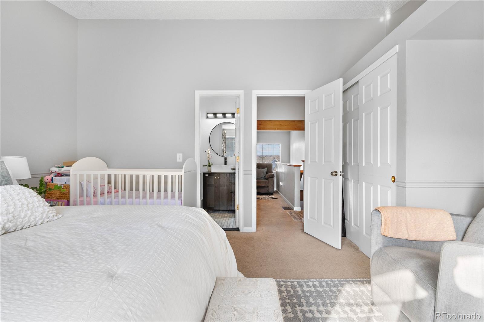 5155 West 68th Avenue, Unit 5 Westminster, CO 80030 - Photo 14 of 33 a bedroom with a bed and a view of bathroom