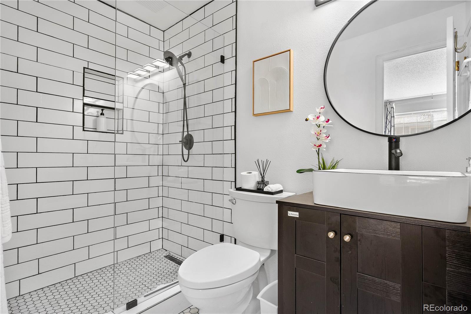 5155 West 68th Avenue, Unit 5 Westminster, CO 80030 - Photo 17 of 33 a bathroom with a sink toilet a mirror and vanity