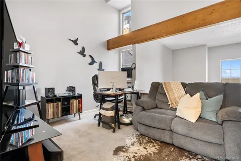 a living room with furniture a flat screen tv and a book shelf