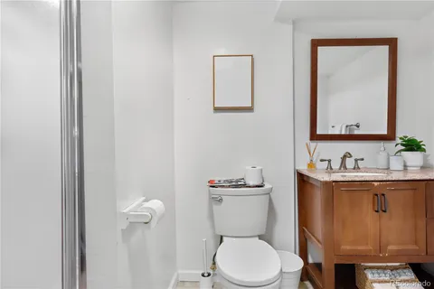 a bathroom with a toilet a sink a vanity and mirror
