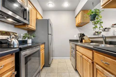 a kitchen with stainless steel appliances granite countertop a sink and a refrigerator