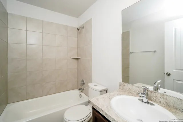 a bathroom with a granite countertop sink toilet and bathtub