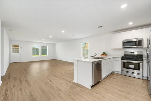 a kitchen with stainless steel appliances granite countertop a stove a sink and a microwave