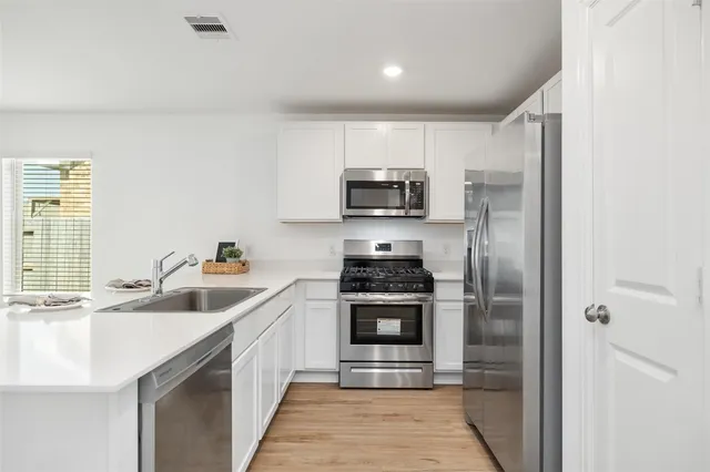 a kitchen with kitchen island granite countertop a sink stainless steel appliances and counter space