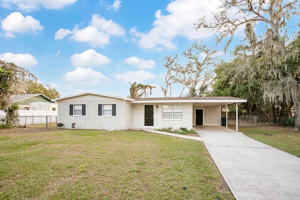 205 Larson Avenue Brandon, FL 33510 - Photo 1 of 1 a front view of a house with a garden and trees