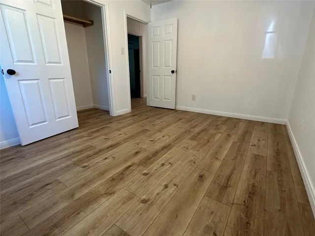 an empty room with wooden floor and closet