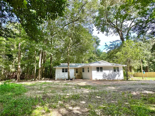 a view of a house with backyard and a tree