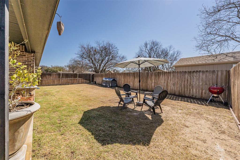 141 Maverick Lane Pilot Point, TX 76258 - Photo 13 of 40 a view of a patio with a table and chairs under an umbrella