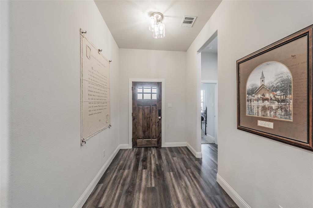 141 Maverick Lane Pilot Point, TX 76258 - Photo 15 of 40 a view of a hallway with wooden floor and a chandelier