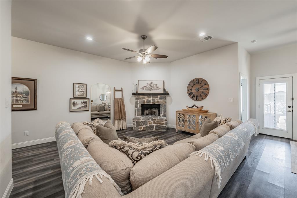 141 Maverick Lane Pilot Point, TX 76258 - Photo 17 of 40 a living room with furniture a clock and a fireplace