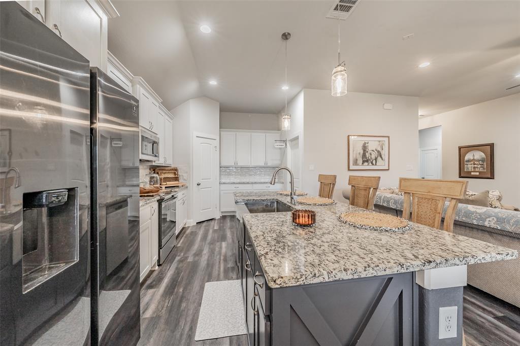 141 Maverick Lane Pilot Point, TX 76258 - Photo 22 of 40 a view of a kitchen with kitchen island a large counter top stainless steel appliances and cabinets