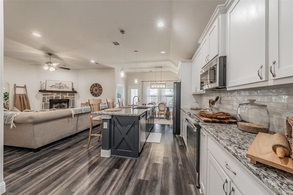 141 Maverick Lane Pilot Point, TX 76258 - Photo 23 of 40 a kitchen with kitchen island granite countertop lots of counter top space