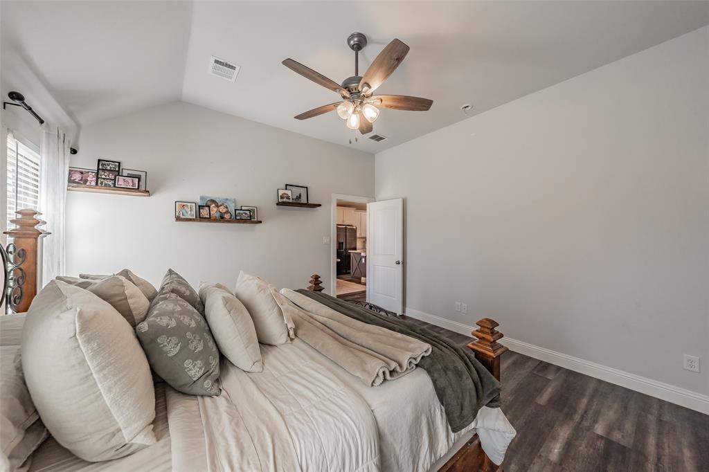 141 Maverick Lane Pilot Point, TX 76258 - Photo 32 of 40 a bedroom with bed and a chandelier