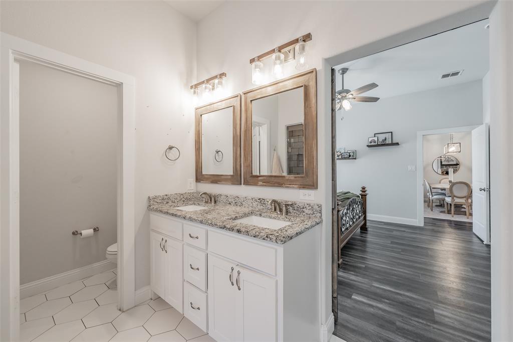 141 Maverick Lane Pilot Point, TX 76258 - Photo 36 of 40 a spacious bathroom with a granite countertop sink and a mirror
