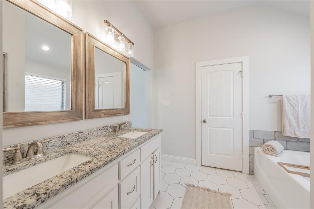 141 Maverick Lane Pilot Point, TX 76258 - Photo 38 of 40 a bathroom with a granite countertop sink and a mirror
