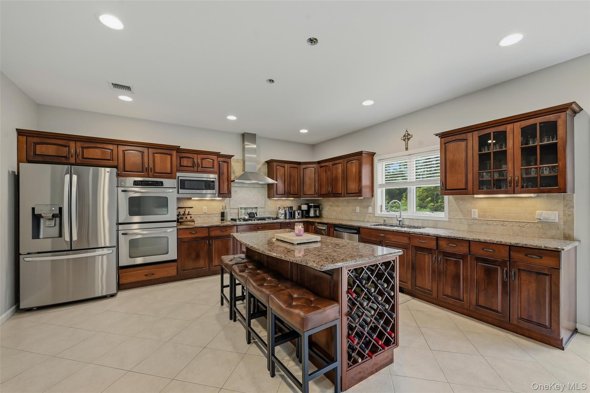 51 Meriwether Trail Congers, NY 10920 - Photo 11 of 50 Kitchen featuring extensive wood cabinetry, stainless steel appliances, a center island with integrated wine storage, granite countertops, and tile flooring