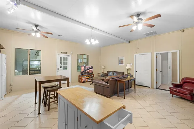 a living room with furniture a dining table and a chandelier