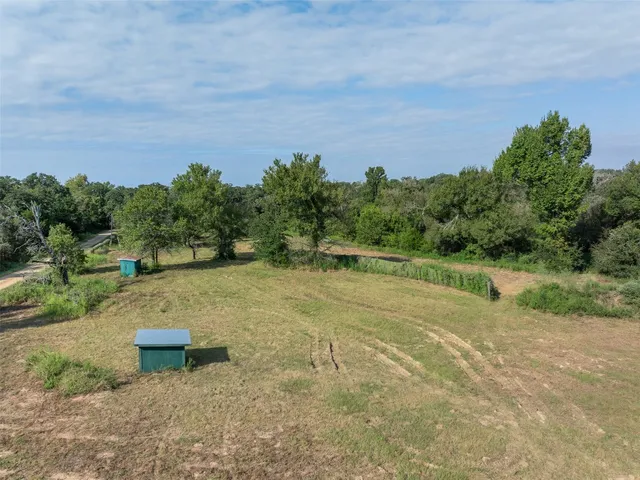 a view of a field with trees in the background