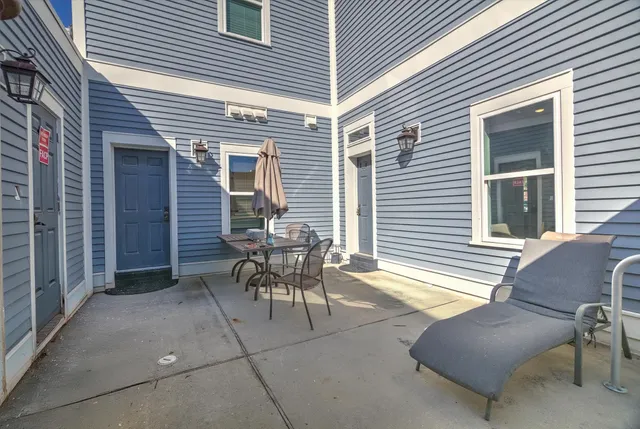 a view of a house with wooden deck and furniture
