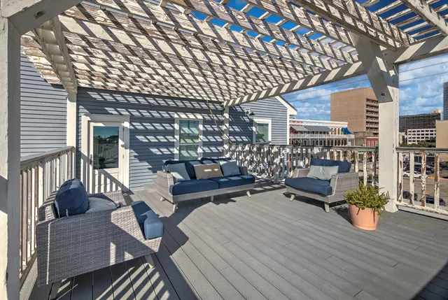 a view of a roof deck with couches and wooden floor