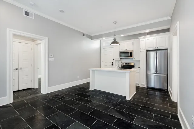 a kitchen that has a stove and a wooden floor
