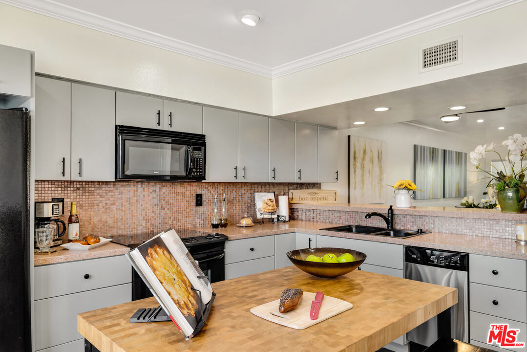 277 East Alejo Road, Unit 119 Palm Springs, CA 92262 - Photo 16 of 46 a kitchen with a stove a sink and a refrigerator