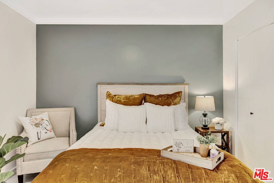 277 East Alejo Road, Unit 119 Palm Springs, CA 92262 - Photo 24 of 46 a bedroom with a bed and a lamp on dresser