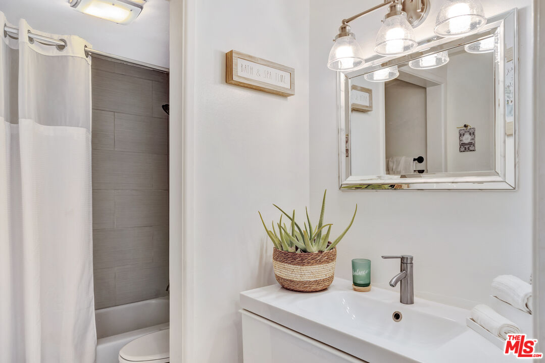 277 East Alejo Road, Unit 119 Palm Springs, CA 92262 - Photo 27 of 46 a bathroom with a sink a mirror and a toilet