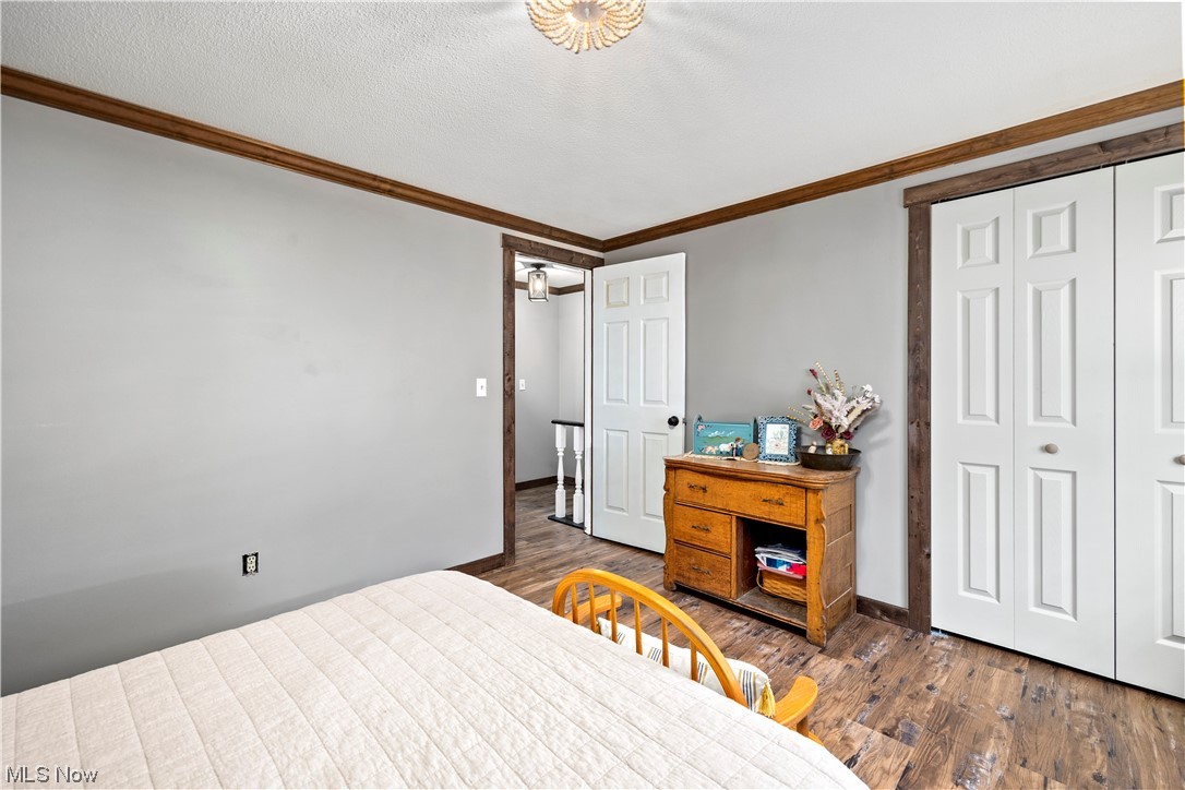41511 Russia Road Elyria, OH 44035 - Photo 27 of 33 Bedroom featuring a closet, a textured ceiling, crown molding, and hardwood / wood-style flooring