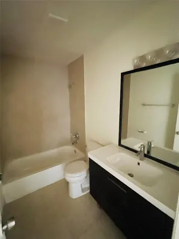 a bathroom with a granite countertop sink a toilet and bathtub