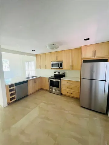 a kitchen with stainless steel appliances a refrigerator a stove a sink a microwave and cabinets