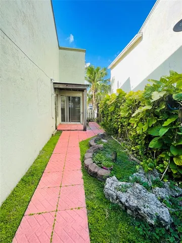 a view of backyard of house with potted plants