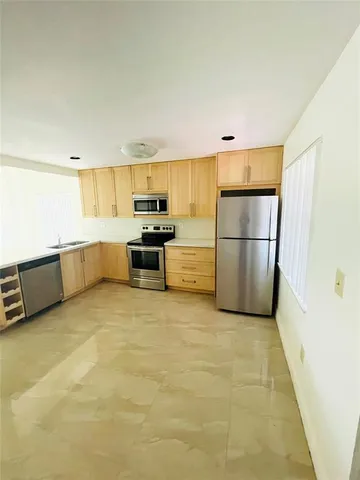 a kitchen with refrigerator and white cabinets