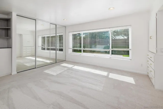 a bathroom with a granite countertop double vanity sink mirror and shower