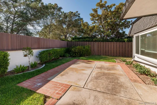 a view of backyard with potted plants and wooden fence