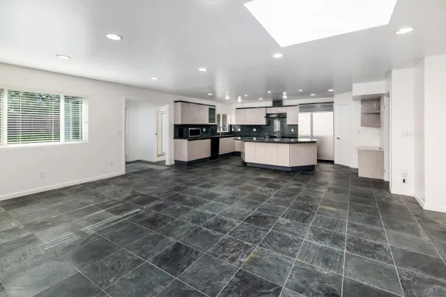 a large kitchen with stainless steel appliances granite countertop a stove a sink and a refrigerator