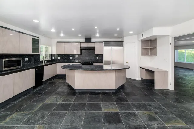 a kitchen with kitchen island a sink stainless steel appliances and cabinets