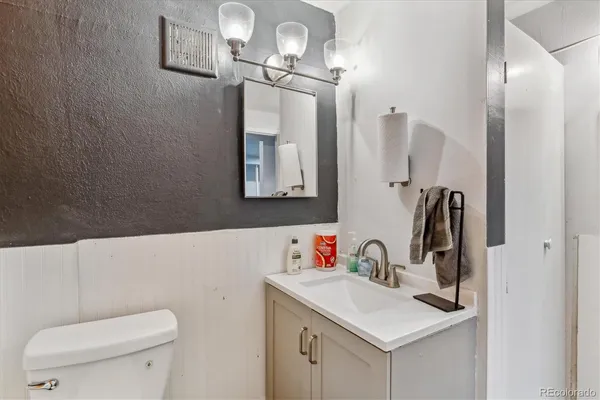 a bathroom with a toilet sink and mirror