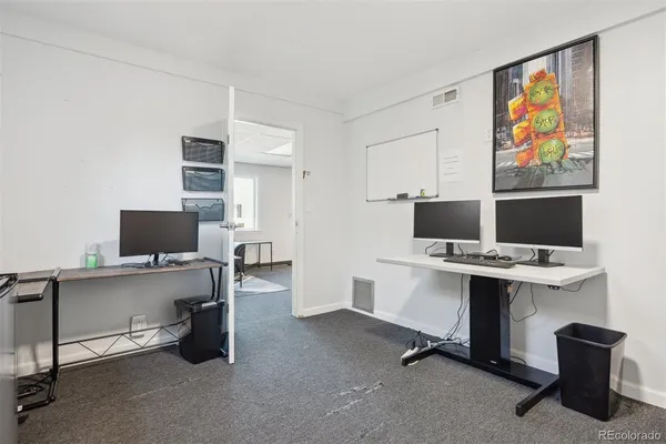 a view of a workspace with furniture and a window