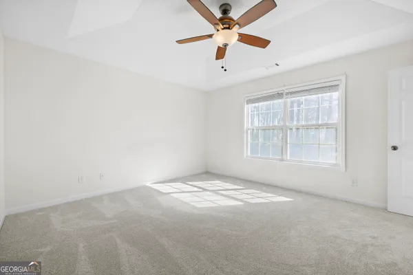 an empty room with fan and windows