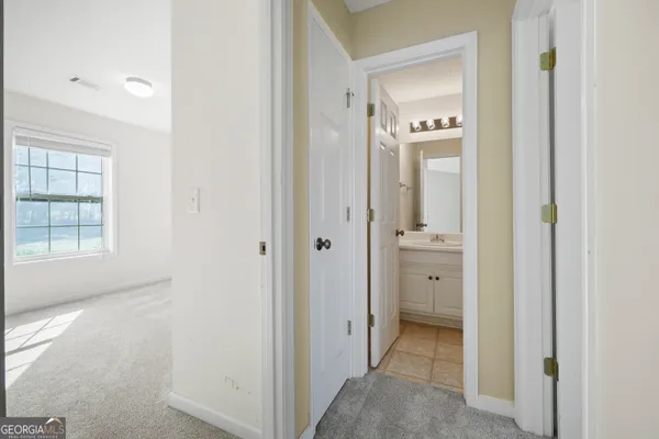 a view of a hallway with a closet and mirror