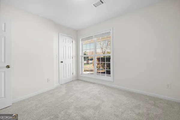 an empty room with a fireplace and a window