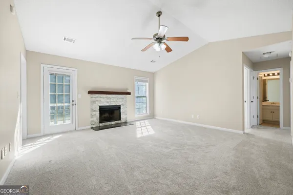 a view of empty room with a fireplace and fan