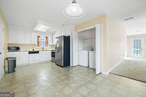 a view of kitchen with refrigerator cabinets and wooden floor