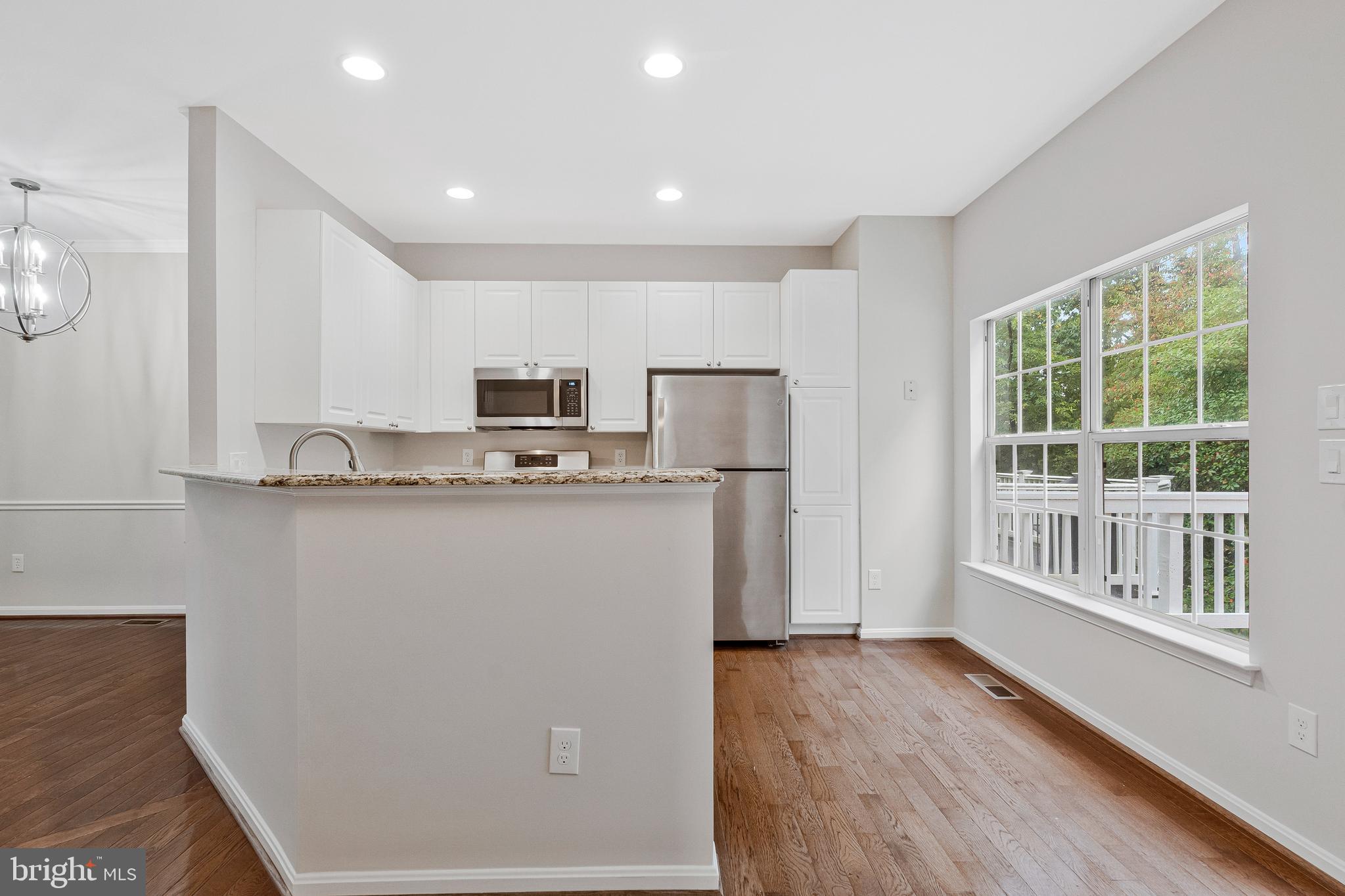 12033 Edgemere Circle Reston, VA 20190 - Photo 13 of 53 a view of kitchen with stainless steel appliances granite countertop a refrigerator a stove a sink and a microwave with wooden floor