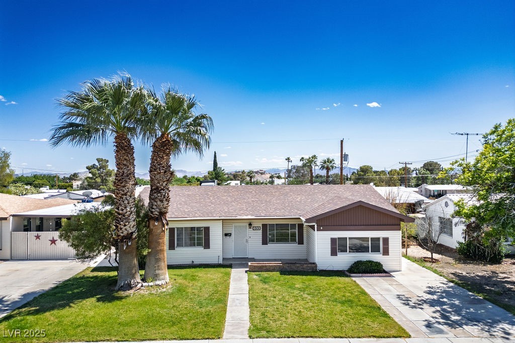 Single story home with a front yard and roof with shingles