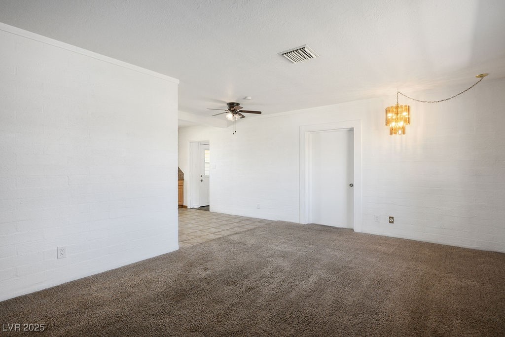 633 5th Street Boulder City, NV 89005 - Photo 14 of 29 Carpeted empty room with a chandelier, crown molding, and a ceiling fan