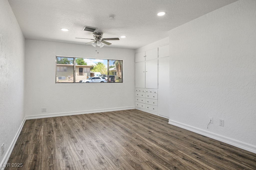 633 5th Street Boulder City, NV 89005 - Photo 19 of 29 Unfurnished room with a textured wall, dark wood-style floors, a textured ceiling, and a ceiling fan