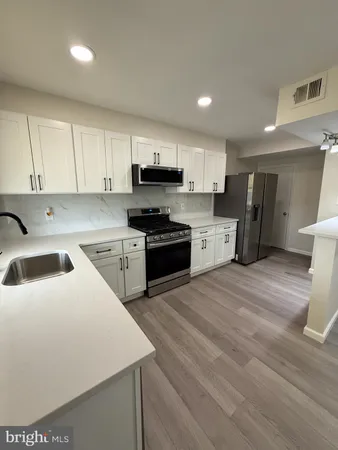 a kitchen with a sink a stove a refrigerator and cabinets
