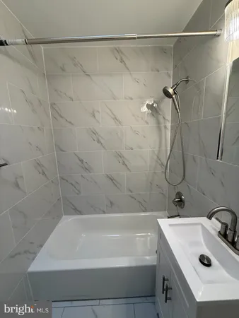 a bathroom with a white bath tub and a sink